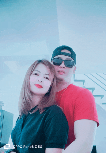 a man and a woman are posing for a picture with an oppo reno8 z 5g