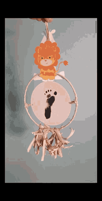 a lion hanging from a hoop with a footprint