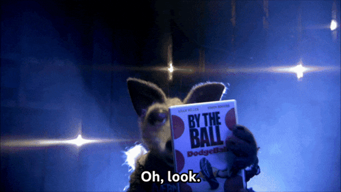 a stuffed animal is holding a book titled by the ball