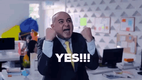 a man in a suit and tie is making a yes sign