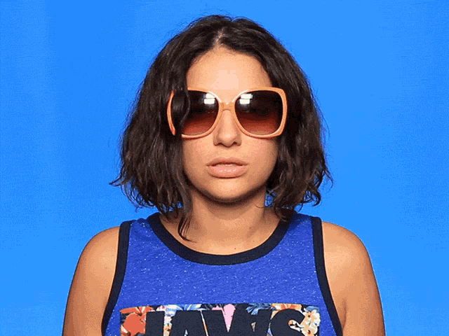 a woman wearing sunglasses and a tank top that says ' levis '