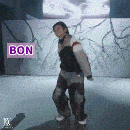 a person is dancing in front of a wall that says bon