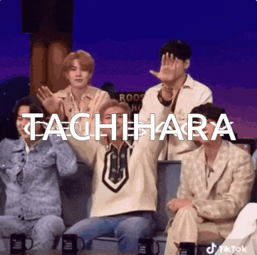 a group of people sitting in front of a sign that says tachihara on it