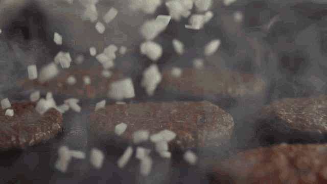 a hamburger patty is being cooked on a grill
