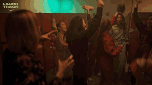 a group of women are dancing in a room with a laugh track logo