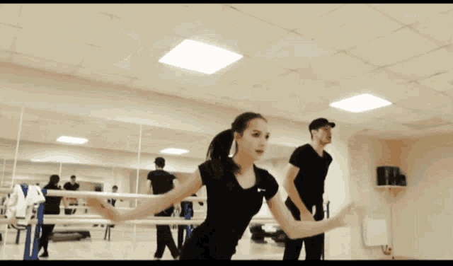 a man and woman are dancing in front of a mirror
