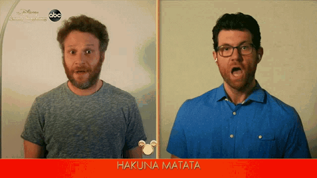 two men are standing next to each other in front of a screen that says hakuna matata on it