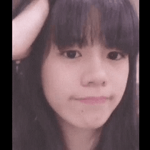 a close up of a young girl 's face with long black hair .