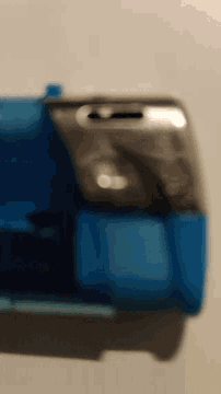 a blurry picture of a cell phone and a blue lighter