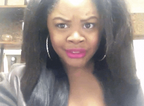 a woman wearing pink lipstick and hoop earrings makes a funny face