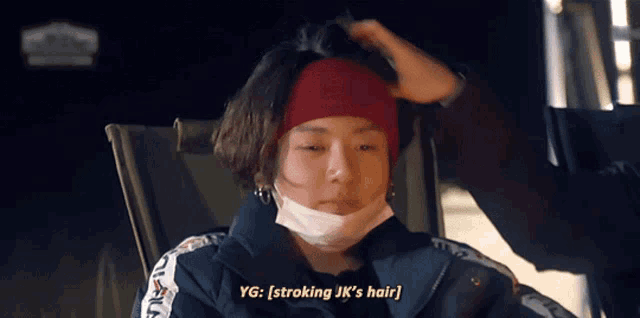 a person wearing a headband and a mask with the words yg : stroking jk 's hair