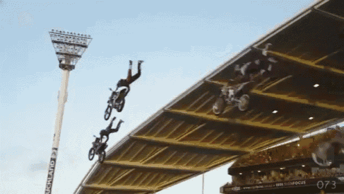 a group of people are doing a trick in a stadium with a sign that says 073 on it