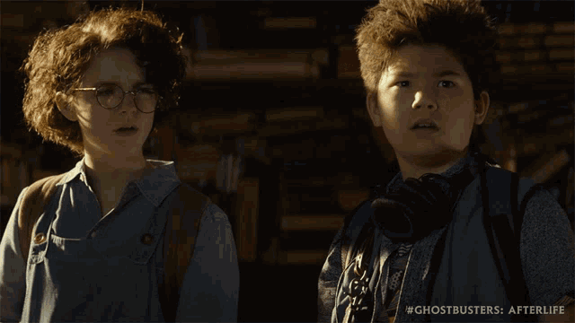 two young boys are standing next to each other in a scene from the movie ghostbusters