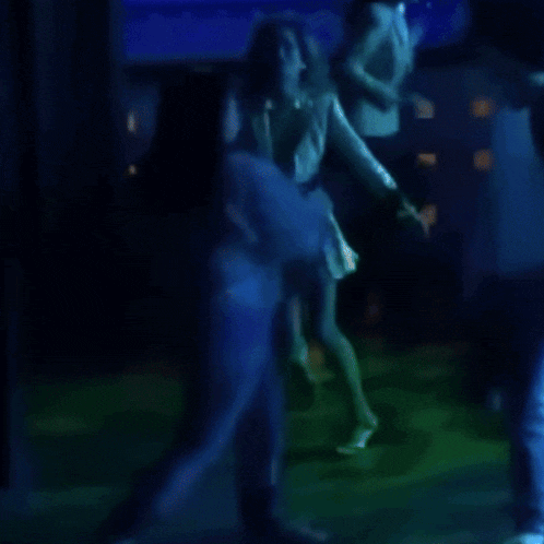 a blurry picture of a group of people dancing in a dark room