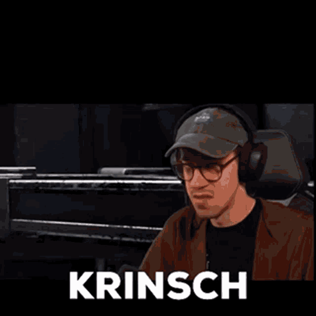 a man wearing headphones and a hat is making a funny face and saying krinsch .