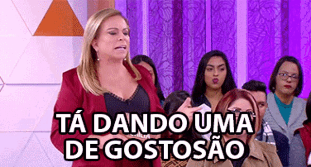 a woman in a red jacket stands in front of a group of people and says ta dando uma de gostosao .
