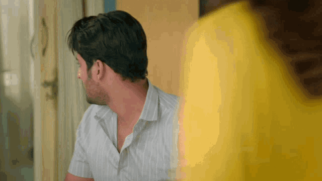 a man in a striped shirt is looking at something