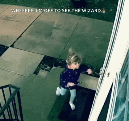 a little girl is running out of a doorway with a cell phone .
