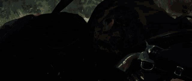 a man with a beard is laying on the ground with a gun in front of him