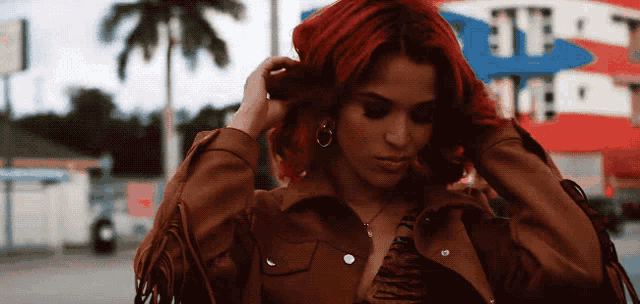 a woman adjusts her hair in front of a pepsi store