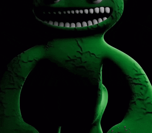 a green stuffed animal with a cross stitched on it