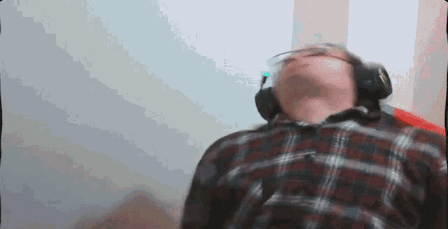 a man wearing headphones and a plaid shirt