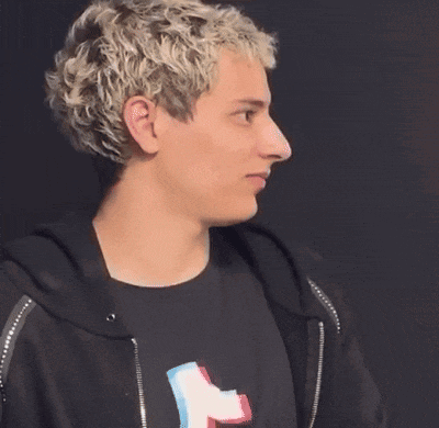a man with blonde hair is wearing a black hoodie