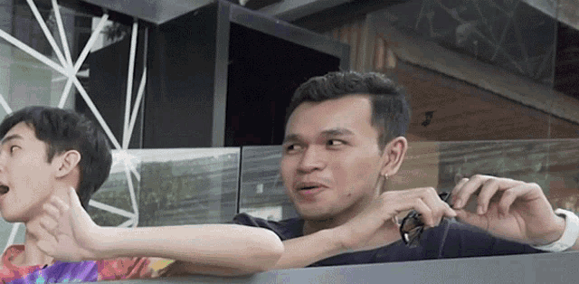 a man in a black shirt is holding another man 's arm