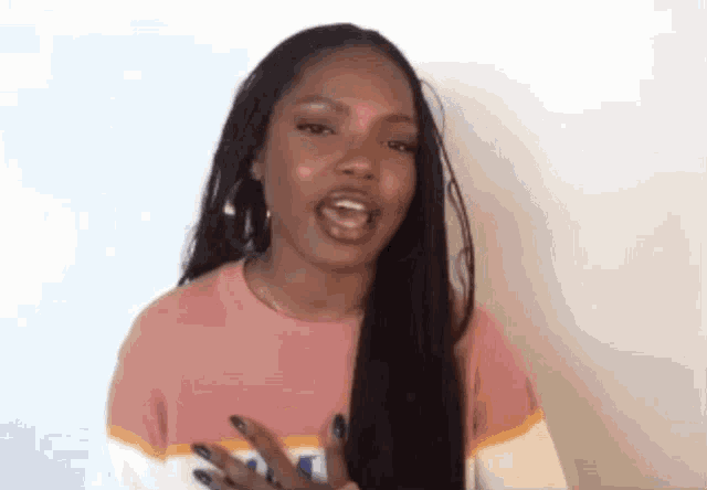a woman with long black hair is wearing a pink and white striped shirt