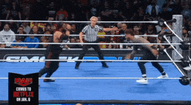 two wrestlers in a ring with a sign that says raw on it