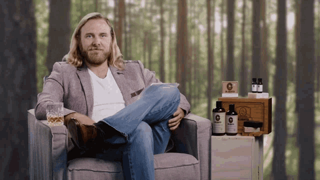 a man sits in a chair with his legs crossed in front of a box that says ' mr. smith ' on it