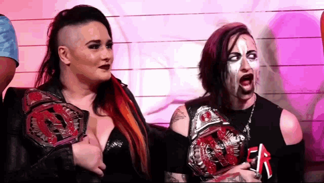 a couple of women are standing next to each other and one of them is wearing a slayer shirt .
