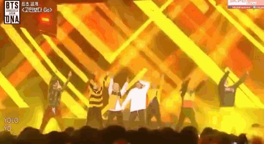 a group of people are dancing on a stage with a sign that says bts