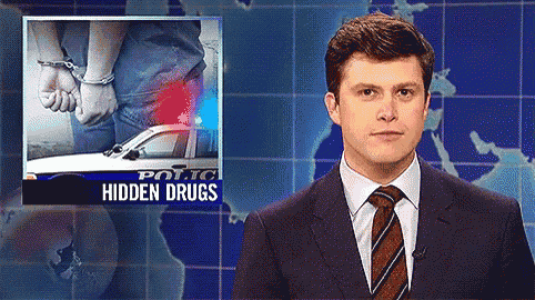 a man in a suit and tie is standing in front of a screen that says police hidden drugs