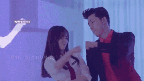 a man and a woman are dancing in front of a purple wall with chinese writing on it