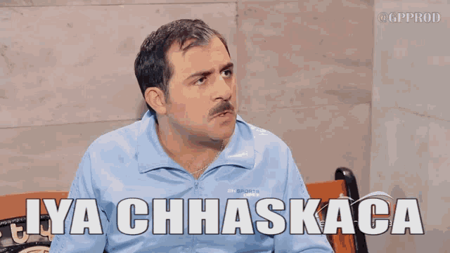 a man sitting on a bench with the words iya chhaskaca above him