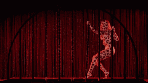 a woman is hanging upside down from a pole in a dark room .