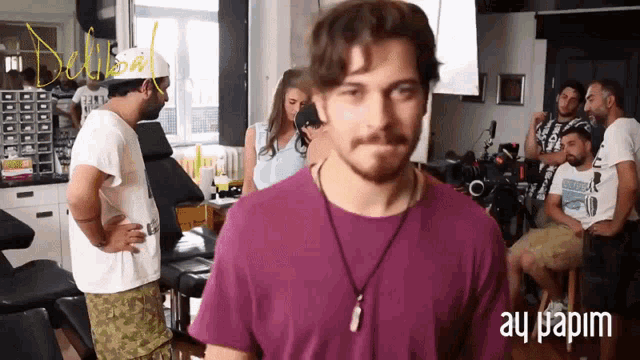 a man in a purple shirt is standing in front of a sign that says " wided he "