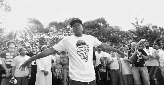 a man wearing a t-shirt with a picture of an ice cream cone stands in front of a crowd