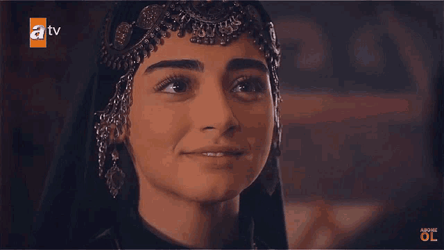 a tv screen shows a woman wearing a headpiece and smiling