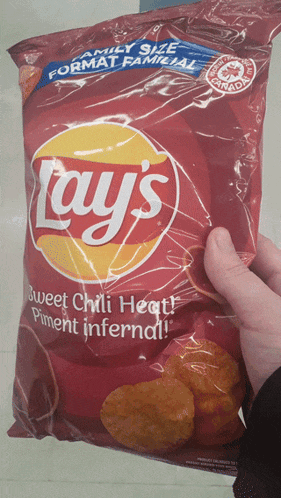 a person is holding a bag of lays sweet chili heat piment infernal chips