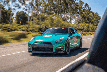 a green sports car is driving down the road with a sticker on the windshield that says legends