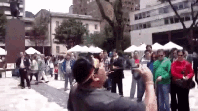 a man taking a picture of a crowd of people in a city