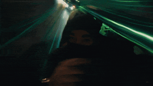 a person wearing a mask is walking down a street at night