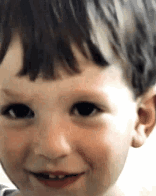 a close up of a child 's face with a smile on it