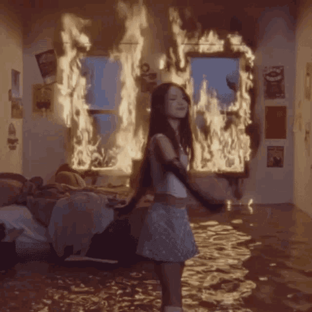 a girl is dancing in front of a room on fire .