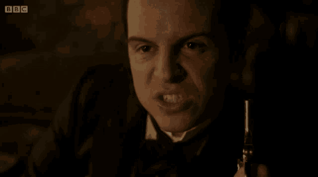 a close up of a man holding a gun with bbc written on the bottom right