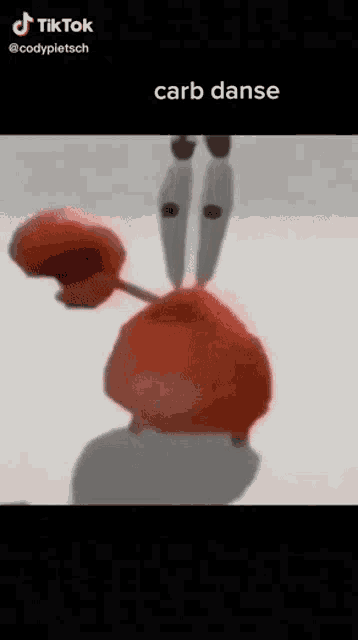 a crab from spongebob squarepants is dancing on a white background .