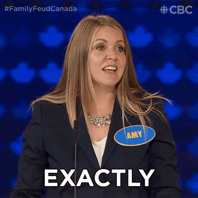 a woman wearing a name tag that says amy stands in front of a microphone and says exactly