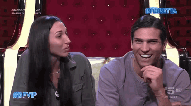 a man and a woman are sitting next to each other and the man is smiling